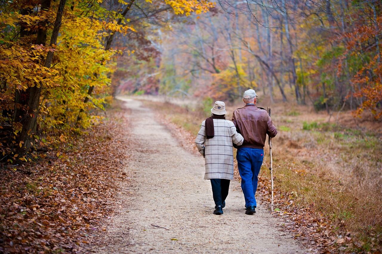 couple-elderly-walking-fall-trail